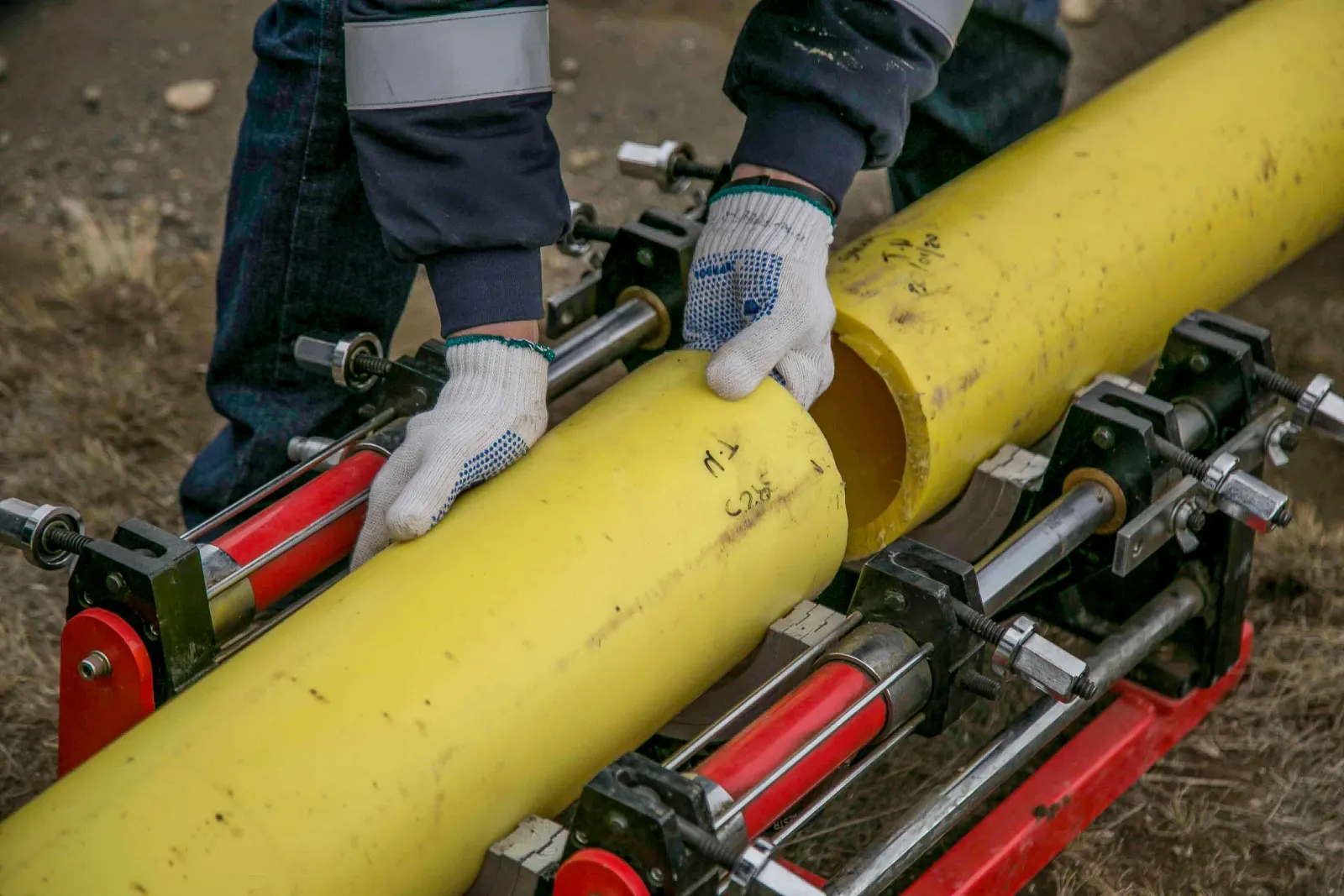 Mains gantées assemblant deux tubes jaunes
